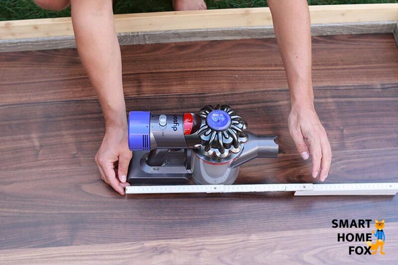 Picture with cordless vacuum cleaner and folding rule: The size of the Dyson V8 Absolute